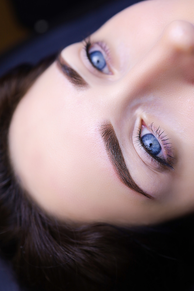 permanent eyebrow makeup close-up. model girl with blue eyes