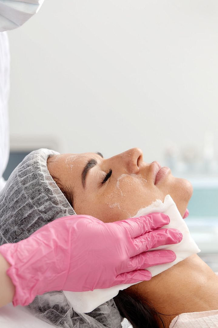 Woman having cleaning facial treatment in spa